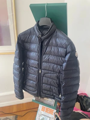 Moncler Acorus jacka - Säljer min Moncler Acorus jacka då den har blivit för liten för mig. Väldigt sparsamt använd och därmed i mycket bra skick. Dustbagen följer med vid köp. Storlek: 3 vilket motsvarar S-M. Färg: marinblå. Mitt pris: 2499 kr. Priset går att diskutera. Hör av er vid funderingar eller för fler bilder.