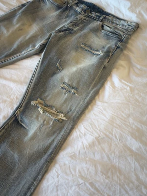 Ljusblå Smokerise flare jeans med slitningar - Mått:  Midja 47cm Lår 29cm Knä 22cm Benöppning 23cm Längd 109cm Några undringar är det bara att fråga.