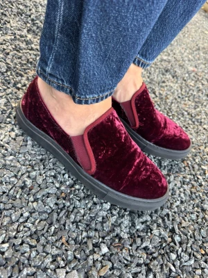 Vinröda Blankens  slip-on sneakers i sammet - Snygga slip-on sneakers i vinröd sammet med elastiska paneler på sidorna för enkel påtagning. Skorna har en svart sula och en låg profil som ger en clean look. Perfekta för dig som vill sticka ut med en unik textur och färg. Från Blankens. Använda några få gånger, som nya. 