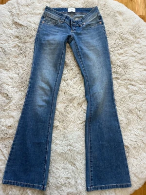 Blå bootcut jeans från Abrand Jeans - Snygga blå bootcut jeans från Abrand. Jeansen har låg midja och utsvängda ben, Innerbenslängden är 83 cm och midjemåttet rakt över är 37 cm. Jag kan gå med på att diskutera priset om det skulle vara så.