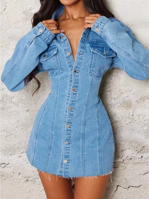 Kort jeansklänning med knappar - Snygg kort jeansklänning i ljusblå denim med långa ärmar och knappstängning framtill. Klänningen har två bröstfickor med lock och markerad midja för en feminin siluett. Perfekt för dig som gillar en trendig och avslappnad stil. Denna klänning är bara använd 1 gång.