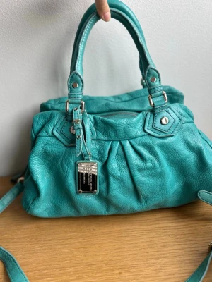 Turkos Marc Jacobs Q väska  - Turkos Marc Jacobs väska, tror det är medelstorleken. Har lite slitningar på vissa ställen och lite fläckig inuti men inga stora defekter, skriv för fler bilder❤️