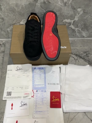 Svarta sneakers med röd sula Louboutin - Hej, säljer dessa jättesnygga Christian Loubitins skor i storlek 41  Skorna är helt nya och är redo att användas✨ Perfekt för dig som vill se mer stilig och fräsch ut😊  kom med frågor och prisförslag Snabb leverans/ bara skor medföljer vid köp