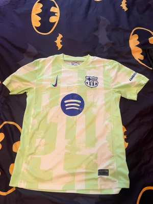 Barcelona matchtröja ljusgrön Nike - Säljer en ljusgrön Barcelona matchtröja från Nike med klubbmärke och sponsorlogga på bröstet. Tröjan har rund hals, korta ärmar och är tillverkad i ett lätt, ventilerande material perfekt för träning eller match.