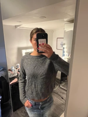 Zara stickad tröja - Mysig grå stickad tröja med rund hals och långa ärmar. Tröjan har en enkel, rak passform och är tillverkad i ett mjukt material som passar perfekt till jeans eller kjol. Perfekt för kyligare dagar och enkel att styla.