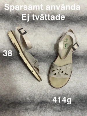 Beige sandaler med spänne och mönster - Snygga beige sandaler med justerbart spänne och dekorativt utskuret mönster på remmen. Sandalerna har en stadig sula och öppen tå, perfekta för varma dagar. Lätta att matcha och ger en fräsch look till din outfit.🌸 Sparsamt använda. Ej tvättade. Storlek 38