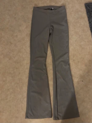 Beiga bootcut leggings - Snygga beiga leggings med bootcut-ben och hög midja. Tillverkade i ett stretchigt material som sitter skönt på kroppen. Perfekta för dig som gillar en enkel men trendig look.