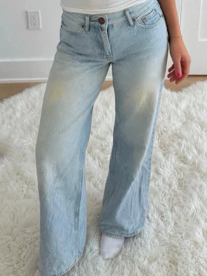 Ljusblåa wide leg jeans - Säljer ett par ljusblåa jeans med wide leg passform. Jeansen har klassiska fem fickor, bälteshällor och knappgylf. Materialet är denim i bomull och färgen har en snygg tvättad look.
