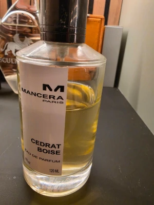 Mancera Cedrat Boise Eau de Parfum - Mancera Cedrat Boise Eau de Parfum i en genomskinlig glasflaska med svart lock. Flaskan rymmer 120 ml och har en stilren vit etikett med svart text. Doften är känd för sina fräscha citrus- och tränoter.