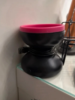 Elektrisk borstrengörare rosa/svart - Elektrisk borstrengörare i svart och rosa med USB-sladd. Skålen har en räfflad insida i silikon för effektiv rengöring av sminkborstar. Perfekt för dig som vill hålla dina borstar fräscha och rena på ett smidigt sätt.