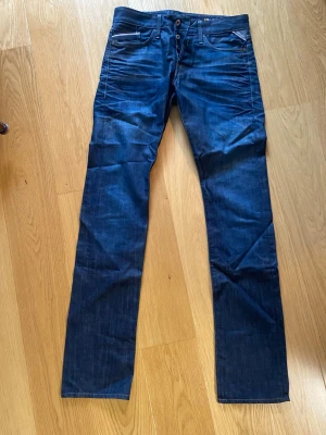Mörkblå raka jeans för långa killar - Snygga mörkblå jeans med raka ben och klassisk femficksdesign. Jeansen har kontrastsömmar och knappgylf. Materialet är slitstark denim i bomull. Storlek 30/36 för långa och smala killar