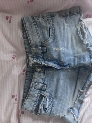 Ljusblå jeansshorts med broderi - Säljer ett par ljus blåa jeans från Gina tricot. Storlek 146