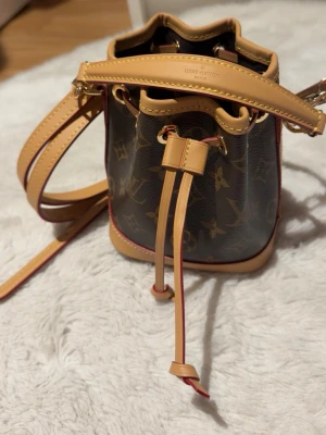 Väska - Snygg bucket bag med klassiskt monogrammönster.