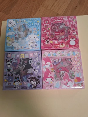 Söta Sanrio klistermärken 40pcs -  Sanrio klistermärken i varje, med motiv av Cinnamoroll, My Melody, Kuromi och björnar. Perfekt för att dekorera anteckningsböcker, mobilskal eller brev. Färgglada och detaljerade figurer i blått, rosa, lila och rött.