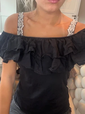 Volang topp - En svart offshoulder volang topp 