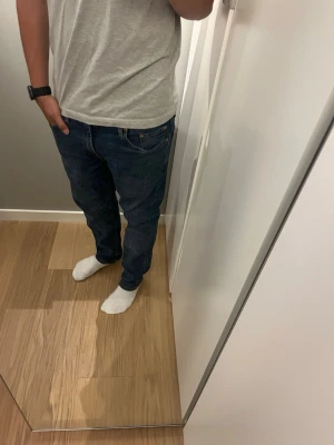 Mörkblå raka jeans från Levis  - Säljer ett par mörkblå jeans med rak passform och klassisk femficksdesign. Jeansen har normal midja och är tillverkade i ett slitstarkt denimtyg. Perfekta för en avslappnad och stilren look. Modellen är 179