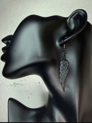 Black Gothic Angel Wing Earrings – Dark Fantasy Alternative Punk Statement 6.8 cm - Svarta örhängen i form av detaljrika änglavingar med gotisk känsla. Perfekta för dig som gillar goth, alternative, punk, rock och dark fantasy. Ett iögonfallande statement som passar både till vardag och festival. Toppskick. Nya gummistoppar medföljer. Mått: ca 6,8 × 1,4 cm. Material: metall. Jag ger gärna bundlerabatt vid köp av flera varor.