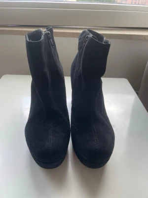 Svarta platåstövletter med klack - Säljer ett par svarta vagabond klackar  med hög klack och platåsula. Skorna har dragkedja på sidan och är gjorda i ett mocka liknande material.😊