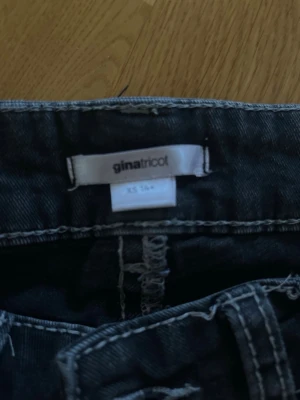 Svarta jeans med broderad ficka XS - Snygga svarta jeans från Gina Tricot i storlek XS. Jeansen har en unik bakficka med broderade detaljer och knappstängning. Perfekta för dig som vill ha något extra till din outfit.