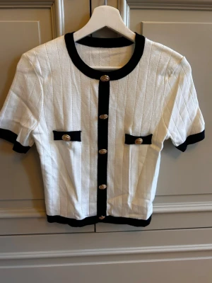  Elegant black & white knitted short-sleeve cardigan with beautiful gold-tone statement buttons ✨ - Elegant black & white knitted short sleeve cardigan with beautiful gold-tone statement buttons. ✨Labeled as size L, but fits more like a size S/M.