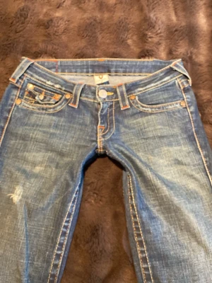 True religion jeans bootcut - Säljer ett par mörk blå true religion jeans med slitningar. Innerbenslängd: 83,5cm.  midja rakt över: 39cm. Säljer eftersom de är lite för tajta på mig som ni kanske ser på bilderna. Bara att kontakta vid frågor!💕köpte för 900kr