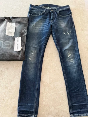 Blå Dondup jeans - Blå dondups me slitningar, säljer pga för små, kvitto, tag och påse medföljer, köpta på Guapa i Göteborg. Skriv om du undrar något!