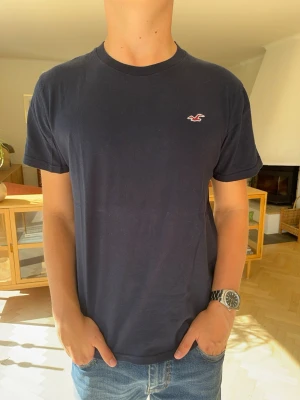 Hollister T-shirt herr mörkblå  - Marinblå kortärmad t-shirt från Hollister i mjuk kvalitet. Snygg kontrast med den ljusare broderade loggan på bröstet. Sparsamt använd och i mycket gott skick. Kolla gärna in mina andra annonser för paketpris!#hollister #tshirt #marinblå #navyblue #herr mode #streetwear #casual #vintedsverige