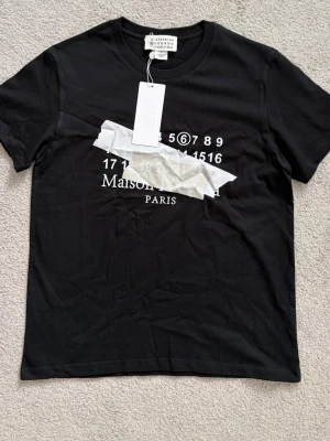 Maison Margiela svart t-shirt - Snygg margiela T-shirt med snygg tryck på framsidan. Storleken är M men sitter som S. Priset går att diskutera.