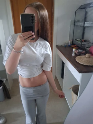 Vit croppad t-shirt med ribbad detalj - Säljer en vit croppad t-shirt med korta ärmar och ribbad detalj i midjan. T-shirten har en enkel och clean look som passar perfekt till höga byxor eller kjol. Materialet känns mjukt och bekvämt mot huden.