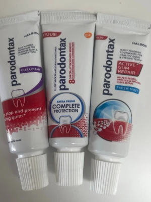 Parodontax tandkräm 3-pack - Tre tuber Parodontax tandkräm i olika varianter: Ultra Clean, Complete Protection Extra Fresh och Active Gum Repair Fresh Mint. Tubarna är vita med färgdetaljer i lila, blått och rött. Perfekt för dig som vill ta hand om tandköttet och få fräsch andedräkt.