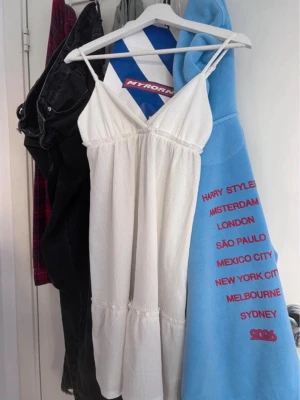 Vit kort klänning från H&M Divided - Säljer en söt vit kort klänning från H&M Divided i storlek XS. Klänningen har smala axelband och v-ringning.  Perfekt för varma dagar och enkel att styla med accessoarer.