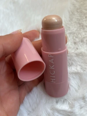 Hickap Sandy Glow Highlighter Stick - Krämig highlighter i stickformat från Hickap i nyansen Sandy Glow. Kommer i en söt ljusrosa hylsa och ger ett skimrande, ljust champagnefärgat glow. Perfekt att applicera direkt på huden för en naturlig lyster. Innehåller 7 g. Aldrig använd!