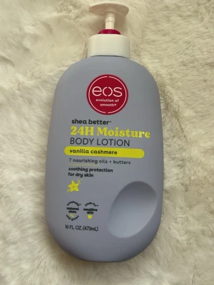 EOS 24H Moisture Body Lotion Vanilla - EOS shea better 24H Moisture Body Lotion i doften vanilla cashmere. Innehåller 7 närande oljor och smör, ger silkeslen återfuktning och skydd för torr hud. Lätt, vegansk och fri från parabener och gluten. Flaska i ljuslila plast med pump, 473 ml.