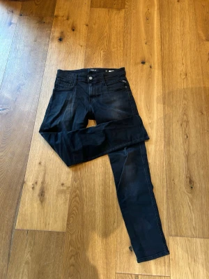 Svarta slim fit jeans - Säljer ett par svarta slim fit jeans med fem fickor och dragkedja. Jeansen har en klassisk design med smal passform och raka ben. Materialet är stretchigt för extra komfort och passform. Perfekta till en avslappnad stil.