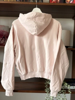 Ljusrosa SKIMS hoodie - Ljusrosa SKIMS hoodie i storlek XS men ficka framtill över magen. Otroligt mysig, söt och gullig hoodie. Hade jag inte haft två likadana hade jag behållt denna! ⭐️Säljes i nyskick, utan defekter & slitage                                 💭Har du frågor? Skriv på annonsen och jag svarar så fort jag kan!