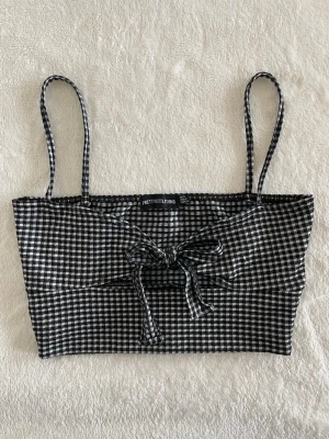 Pretty little thing svartvit rutig crop top - En söt knyt-topp med ett rutigt mönster i svart och vitt, storlek 34. Den har inga defekter 