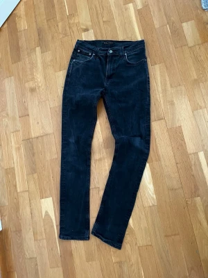 Svarta slim fit jeans - Snygga svarta slim fit jeans med klassisk femficksdesign och raka ben. Jeansen har svarta sömmar och knappgylf. Perfekta till en avslappnad streetwear-look och passar till det mesta i garderoben.