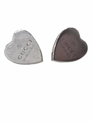 Äkta Gucci örhängen i sterling silver  - Snygga hjärtformade örhängen i silverfärgad metall med texten 'CUCCI made in Italy' ingraverad på framsidan. Klassisk och stilren design som passar till många olika looks. Stiftet har märkningen 925 vilket tyder på äkta silver.