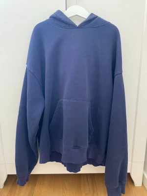 Mörkblå hoodie från Gina Tricot XS - En oversized mörkblå hoodie från Gina Tricot, basically basics-kollektionen. Hoodien har en stor känguruficka framtill, ribbade muddar vid ärmslut och nederkant samt en klassisk huva. Perfekt för en chill och avslappnad stil.