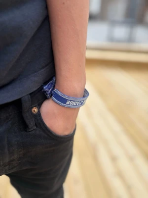 armband - Snyggt blått tygarmband med vit text. Perfekt accessoar för att ge din outfit en cool och trendig touch. har 8st i lager!