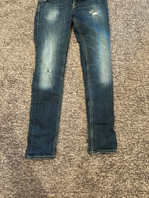 Mörkblå skinny jeans dondup  - Hej! Säljer ett par mörkblå  jeans med slitningar från dondup. Jeansen har en tvättad look. Perfekta för dig som gillar en avslappnad och trendig stil. 