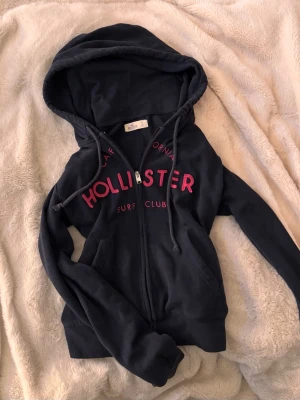 Hollister vintage zip  - Vintage yk2 mörkblå hollister zip huvtröja/kofta med rosa tryck, bra skick o stl S!💓