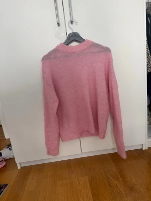 Rosa fluffig stickad tröja Sissy-Boy - Supersöt rosa stickad tröja från Sissy-Boy med rund hals. Perfekt för dig som gillar mysiga och trendiga plagg i garderoben.