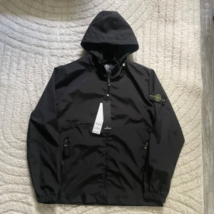 Stone Island Windbreaker - Säljer en snygg vindjacka från Stone Island. Jackan är helt oanvänd. Fick den som present, men kom aldrig till någon användning därmed säljer jag den! Pris går att diskuteras.