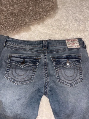 Blå True Religion jeans - Säljer dessa blåa joey true religion jeans i storlek 30! Köpte dessa på vinted nyligen men tyvärr passar dom inte mig så därför väljer jag att sälja vidare dom! Dom är alltså inte använda av mig, men vet ej hur mycket dom användes av förra ägaren, men det inga fel på dom alls och dom ser helt nya ut! Kommer inte gå under 700 eftersom jag köpte dom för 750kr och vill inte gå back för mycket! Tycker även det är ett bra pris för jeans som är nästan helt nya och kostar 1200-2000kr egentligen🥰🥰🥰