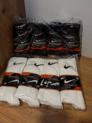Nike strumpor svart/vit - Nike strumpor i svart och vitt med klassisk Nike-logga. Strumporna är ribbade och tillverkade i mjuk bomullsmix som passar perfekt till träning eller vardag. Säljs i flerpack och har en sportig look. Ett pack = 12st strumpor.