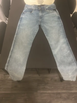 Ljusblå replay jeans - Säljer ett par ljusblå replay jeans med klassisk femficksdesign. Jeansen har en snygg tvättad look och är gjorda i denim. Perfekta för dig som gillar en avslappnad stil och vill ha ett par tidlösa jeans i garderoben.