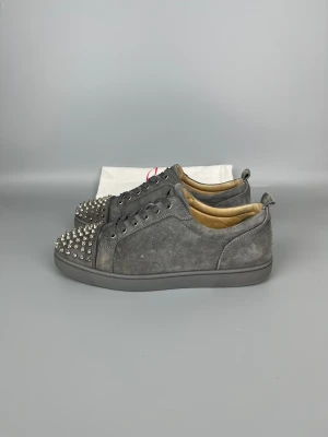 Christian Louboutin Louis Junior Spikes Sneaker Grey | 43.5 - Låg använt sneaker i mycket gott skick, grå färg. Dustbag ingår.