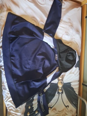 Blå och svart Nike hoodie med huva mycke bra - Snygg mörkblå hoodie från Nike med svart huva och vita detaljer. Klassisk passform med långa ärmar och ficka framtill. Tillverkad i mjukt material som känns skönt mot huden. Perfekt för dig som gillar sportig och avslappnad stil.