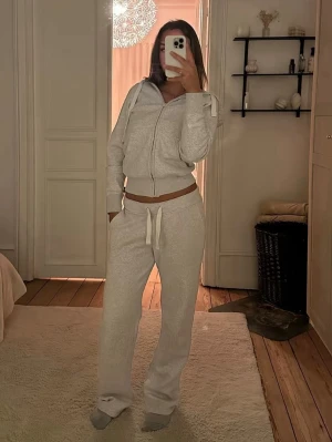 Grått mjukisset från Russemerch  - Säljer ett supermysigt grått mjukisset från Russemerch med hoodie och byxor. Hoodien har dragkedja och fickor, byxorna har dragsko i midjan och raka ben. Perfekt för chill dagar hemma eller när du vill vara bekväm. Materialet är mjukt och skönt mot huden. Nypris för hela setet är 1 250kr. 